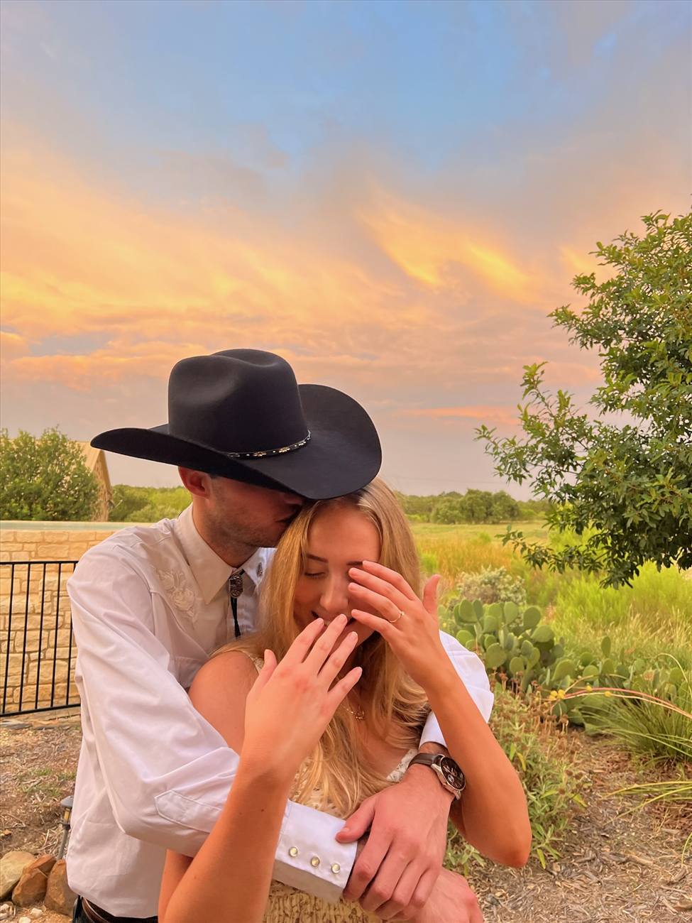 Tyler kissing Lauren's forehead in the warm evening light