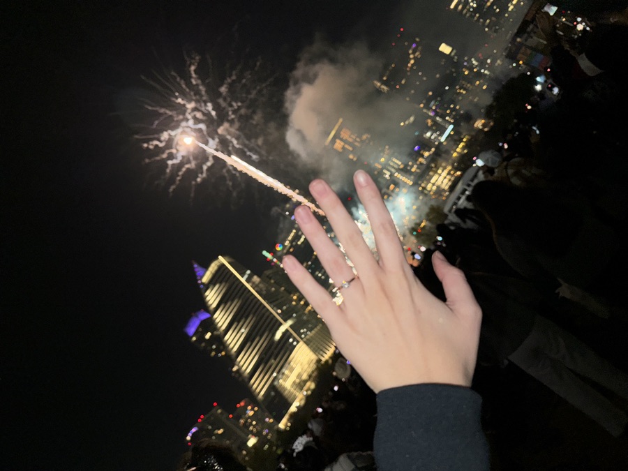 The ring, held up against fireworks over the city